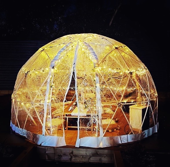 Igloo dome lit golden at night from outside